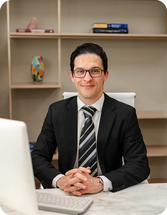 Dr. André de Val Barreto sentado à mesa do consultório